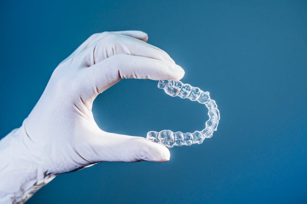 Nakładka Invisalign w białej rękawiczce