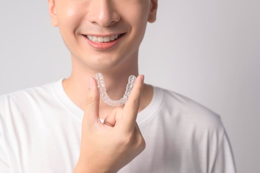 Mężczyzna trzyma w ręce invisalign